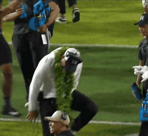 Man in Lei Kneeling on Football Field