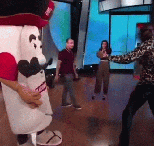 Man in Leopard Print Shirt Standing in Front of Marshmallow Mascot