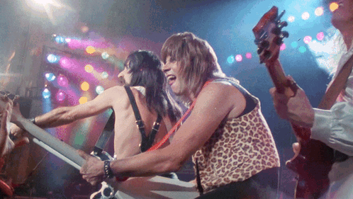 Man in Leopard Print Vest Playing Guitar in Band