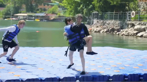 Man in Life Jacket Carrying Another Man on Raft