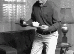 Man In Living Room Holding Tray With Food GIF