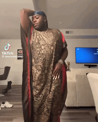 Man in Long Dress in Front of TV With Tik Tok Sign