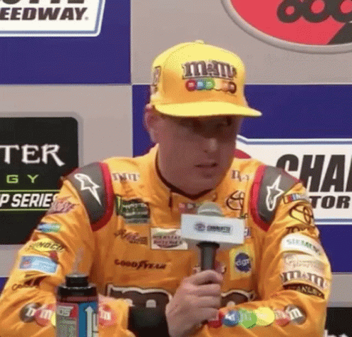 Man in M&M's Hat Holding Microphone