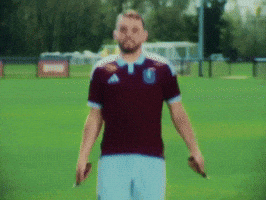 Man in Maroon Adidas Shirt on Green Field