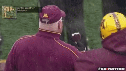 Man in Maroon Jacket With Letter A Eating Football