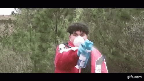 Man In Mask And Gloves Holding Spray Bottle Pointing At Camera GIF