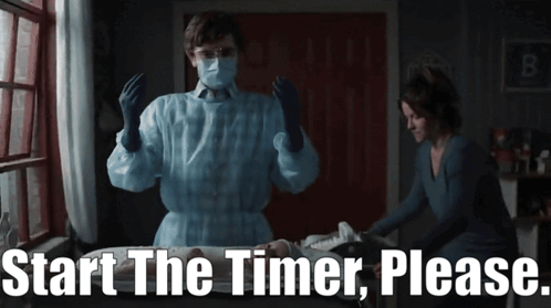 Man in Mask and Gloves Next to Woman Saying Start the Timer Please