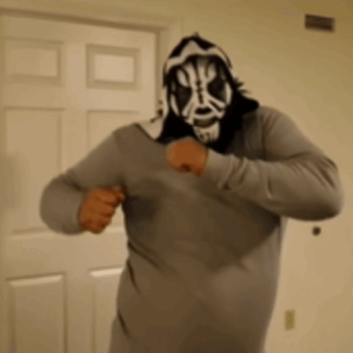 Man in Mask and Hoodie Standing in Front of Door