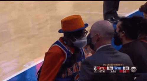 Man in Mask and Orange Hat Talking to Referee