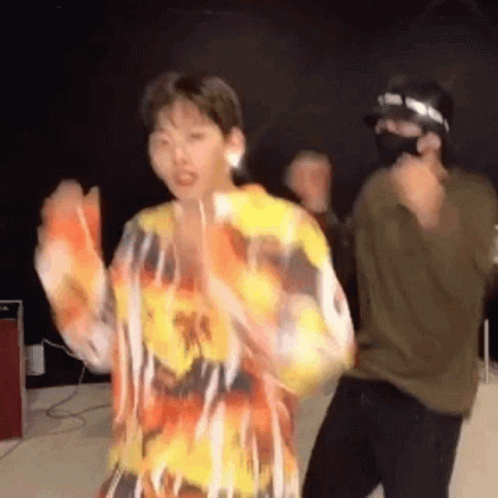 Man in Mask Dancing With Woman in Colorful Shirt