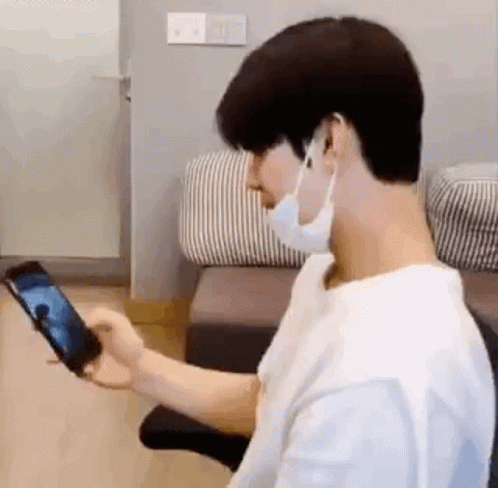 Man in Mask Holding Cell Phone