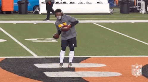 Man In Mask Holding Football On Field GIF
