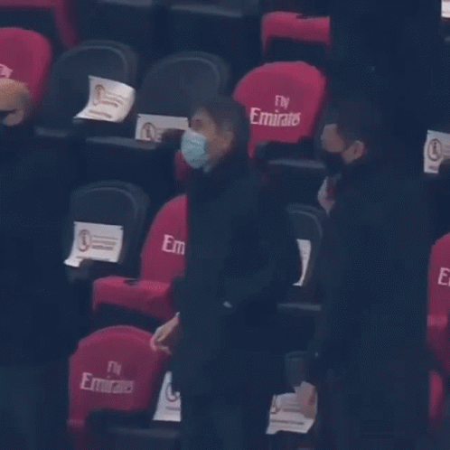 Man in Mask in Front of Fly Emirates Chairs
