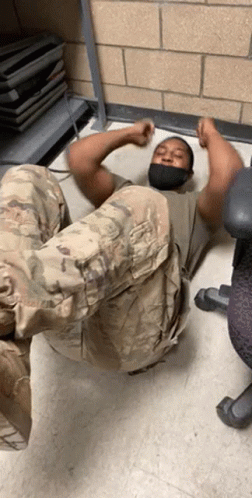 Man In Mask Laying On Floor With Legs Up GIF