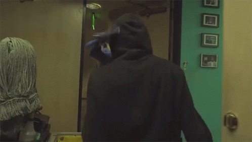 Man in Mask Standing in Front of Door