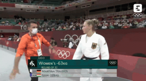 Man in Mask Talking to Woman in Judo Match