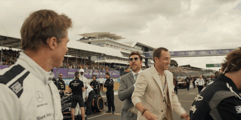 Man in Mercedes Shirt Talking to Suit