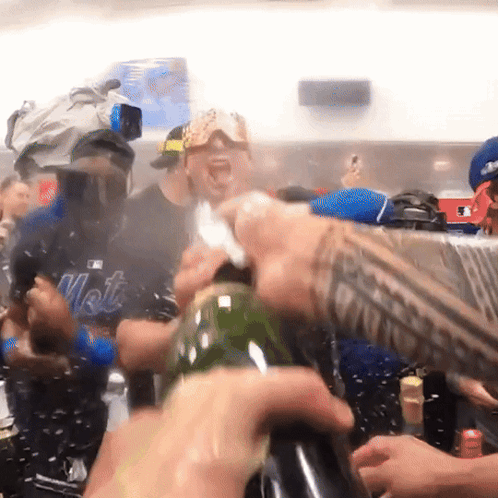 Man in Mets Shirt Opening Bottle