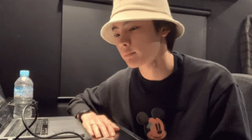 Man in Mickey Mouse Shirt Sitting at Laptop
