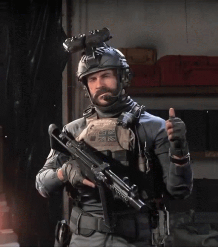 Man in Military Uniform Holding Gun and Thumbs Up