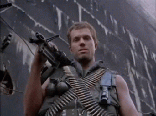 Man in Military Uniform Holding Gun in Front of Ship