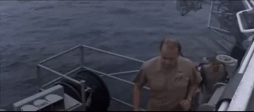 Man In Military Uniform On Boat Looking At Camera GIF