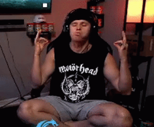Man in Motörhead Tank Top Eyes Closed in Lotus Position