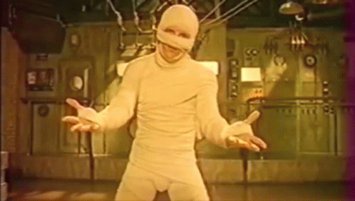 Man In Mummy Costume In Front Of Wall Number 99 GIF