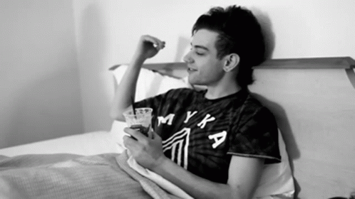 Man In Myka Shirt Laying On Bed GIF