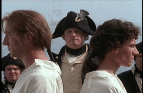 Man In Napoleonic Hat Between Two Men In White Shirts GIF