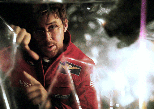 Man in NASA Jacket Looking Through Glass