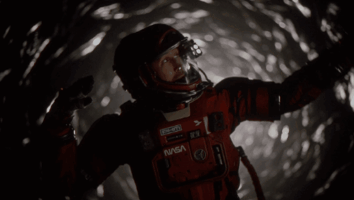 Man in NASA Space Suit Standing in Dark Tunnel