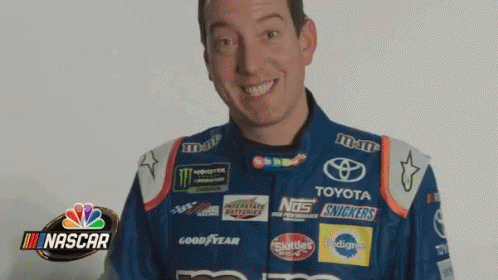 Man in Nascar Uniform Smiling Holding Snickers Bottle
