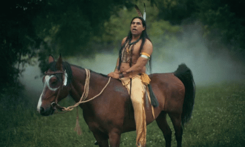Man in Native American Outfit Rides Horse