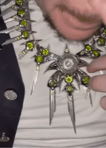 Man in Necklace With Green Stones and Black Tie