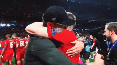 Man in New Balance Hat Hugging Another Man
