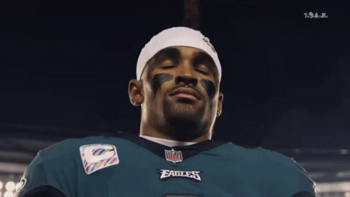 Man in NFL Eagles Jersey Looking Down Eyes Closed