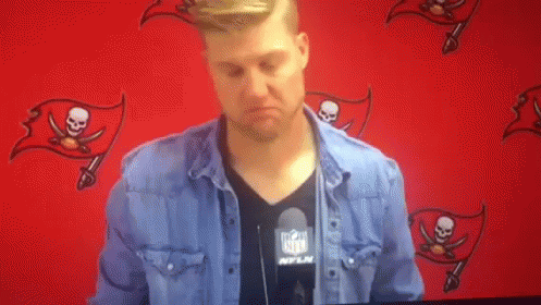 Man in NFL Shirt Standing at Red Wall