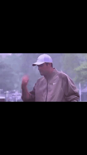 Man in Nike Jacket Holding Frisbee Over Head