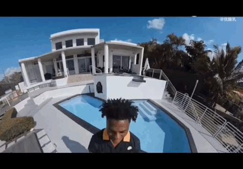 Man in Nike Shirt in Front of House and Pool