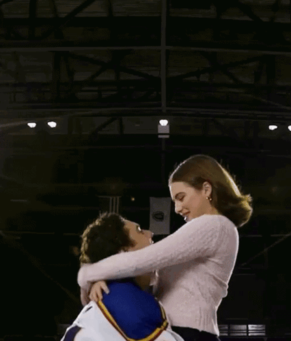 Man in Number 4 Jersey Holding Woman