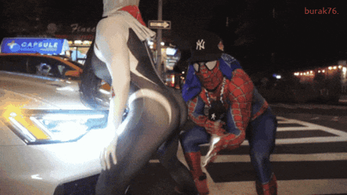 Man in NY Hat Next to Woman in Spiderman Suit