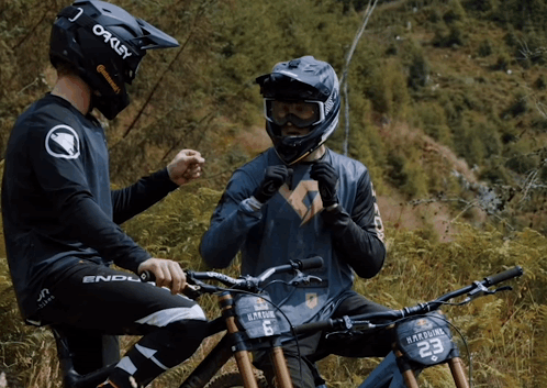 Man in Oakley Helmet Talking to Another Man on Bike