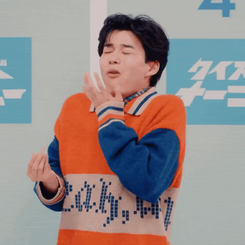 Man in Orange and Blue Sweater Making Funny Face