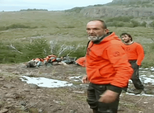 Man in Orange Jacket on Hillside