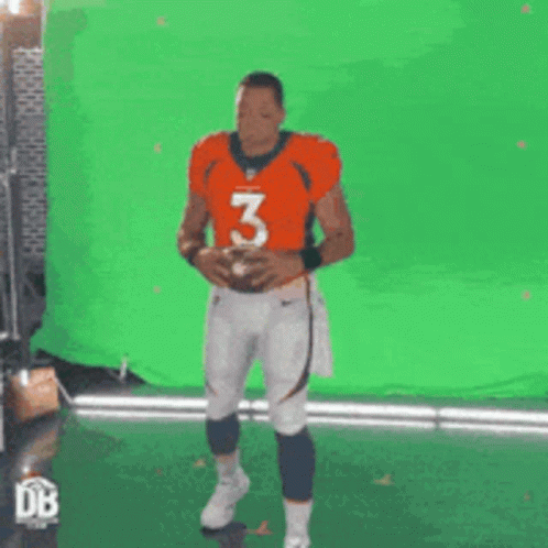 Man in Orange Jersey Number 3 Holding Football