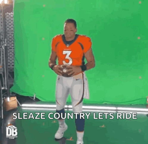 Man in Orange Jersey Number 3 Holding Football