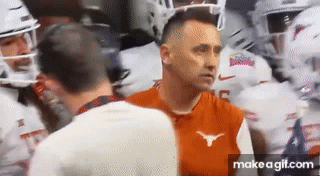 Man in Orange Longhorn Shirt Talking to Man in White Shirt