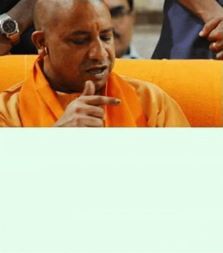 Man in Orange Scarf and Watch Sitting on Couch