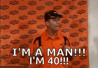 Man in Orange Shirt and Black Hat Saying I'm a Man